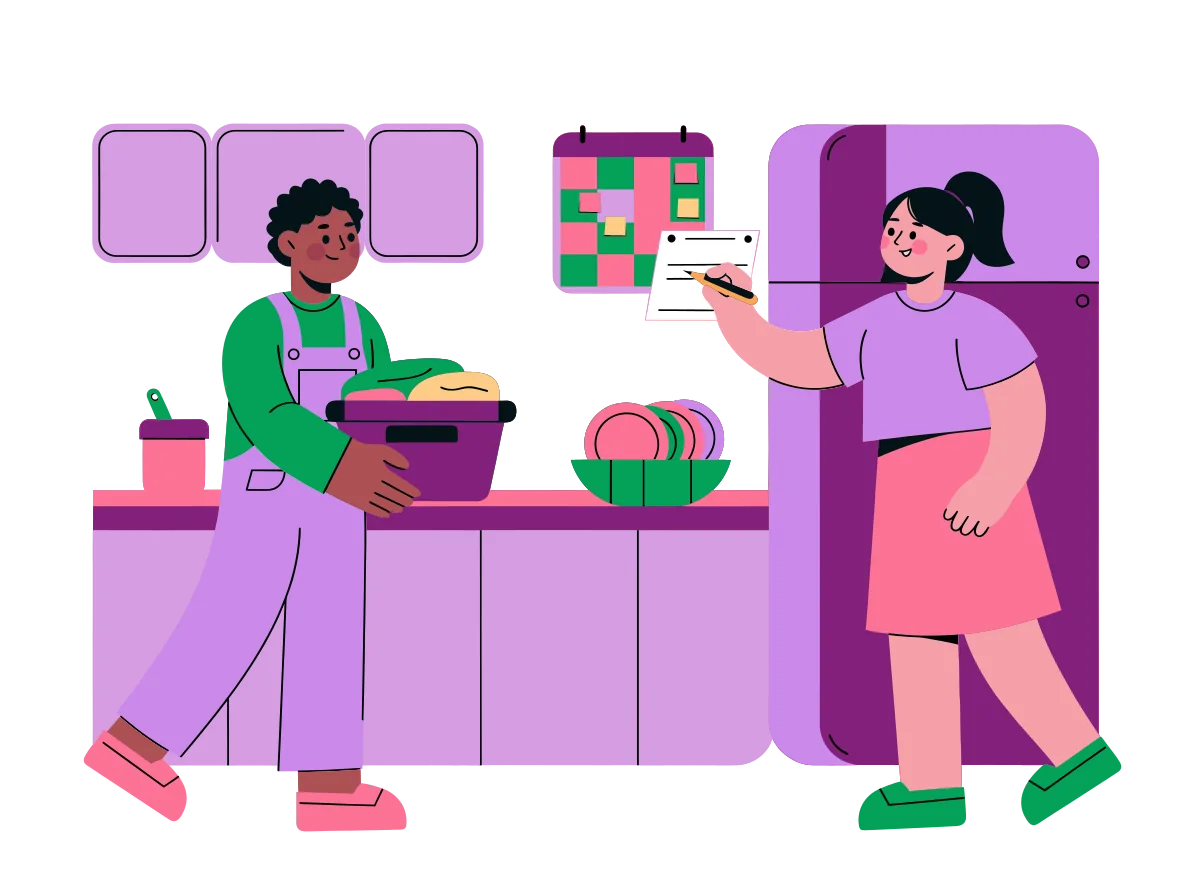 A couple sharing housework in a bright kitchen, one carrying a laundry basket while the other writes on a list on the fridge
